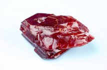Red mineral gemstone on plain background. — Stock Photo