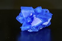 Blue mineral gemstone on mirror surface. — Stock Photo