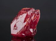 Красный минеральный камень на зеркальной поверхности
. — стоковое фото