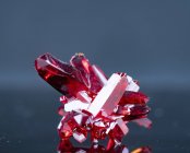 Красные минеральные кристаллы на сером фоне
. — стоковое фото