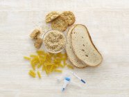 Draufsicht auf Brot und Pasta mit Zöliakie-Testgeräten, Studioaufnahme. — Stockfoto