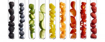 Colorful fruits and vegetables in test tubes, studio shot. — Stock Photo