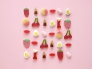 Arranjo de doces de goma colorido em forma no fundo rosa . — Fotografia de Stock