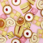 Baked cakes and biscuits on pink background, full frame. — Stock Photo