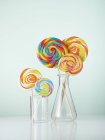 Laboratory glassware with colorful lollipops. — Stock Photo