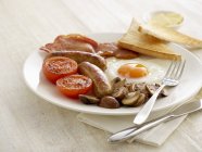 Full English breakfast served on plate on table. — Stock Photo
