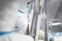 Techniciens travaillant avec la boîte à gants dans un laboratoire biomédical scellé et stérile
. — Photo de stock