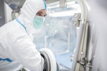 Technicien masculin utilisant la boîte à gants en laboratoire stérile . — Photo de stock