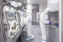 Technicians working in sealed and sterile biomedical laboratory. — Stock Photo