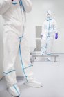 Tecnici che attraversano una cabina di decontaminazione prima di entrare in un laboratorio sterile . — Foto stock