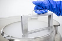 Close-up do técnico que armazena amostras de células estaminais em crioarmazenamento . — Fotografia de Stock