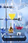 Colorful liquids in laboratory glassware while chemistry experiment. — Stock Photo