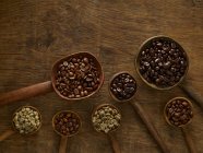 Wooden spoons with coffee beans on rustic background. — Stock Photo
