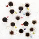 Colorful cups of coffee on table, high angle view. — Stock Photo