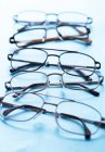 Primer plano de varios pares de anteojos en superficie azul . - foto de stock