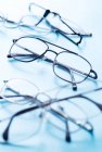 Nahaufnahme verschiedener Brillenpaare auf blauer Oberfläche. — Stockfoto