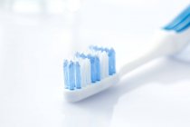 Біло-блакитна зубна щітка на звичайному фоні . — стокове фото