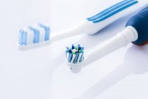 Электрические и ручные зубные щетки на белом фоне . — стоковое фото