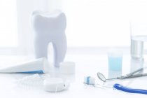 Dental clinic equipment and tooth model against white background. — Stock Photo