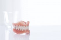 Dentiers sur table sur fond blanc . — Photo de stock