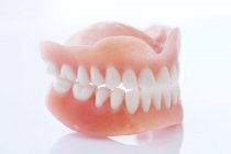 Dentures on table against white background. — Stock Photo