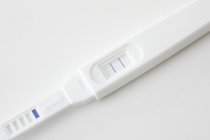 Test di gravidanza che mostra risultati positivi su sfondo bianco . — Foto stock
