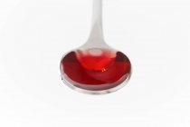 Cough syrup on spoon on white background, studio shot. — Stock Photo