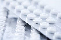 Píldoras anticonceptivas blancas en ampollas, inyección de estudio . - foto de stock
