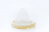 Männliches Kondom auf weißem Hintergrund, Studioaufnahme. — Stockfoto