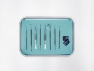 Zahnarztgeräte in Tablett vor weißem Hintergrund. — Stockfoto