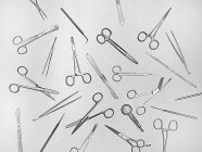 Surgical scissors and tools against grey background. — Stock Photo