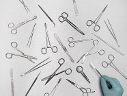 Doctor hand selecting surgical equipment against grey background. — Stock Photo