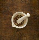 Ervas em argamassa e pilão medicina alternativa sobre fundo de madeira . — Fotografia de Stock