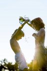 Ragazzi versando acqua l'uno sull'altro da bottiglia di plastica e ridendo . — Foto stock