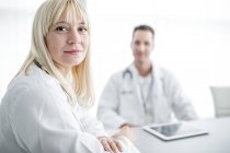 Female doctor looking over shoulder and smiling in clinic interior. — Stock Photo
