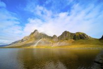 Montagne costiere sotto il cielo blu in Islanda
. — Foto stock