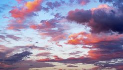 Rosa Wolken am blauen Himmel bei Sonnenuntergang. — Stockfoto