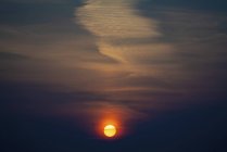 Scenario sul cielo scuro e sole arancione al tramonto
. — Foto stock