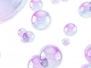 Bolle di sapone viola isolate su sfondo bianco . — Foto stock