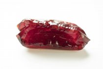 Red gem crystal on white background. — Stock Photo