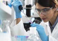 Wissenschaftler pipettiert Probe in Röhrchen für analytische Tests im Labor. — Stockfoto
