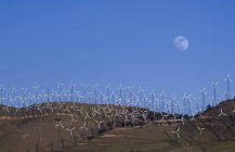 Wind farm with turbines under blue sky and moon, Tehachapi, California, USA. — Stock Photo