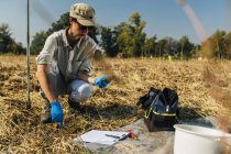 Женщина-агроном измеряет температуру почвы с помощью термометра в поле . — стоковое фото