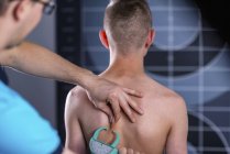 Physiothérapeute effectuant un test de pli de la peau pour mesurer la graisse corporelle des adolescents garçons . — Photo de stock