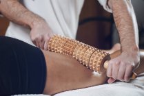 Close-up of woman having anti-cellulite maderotherapy with rolling pin. — Stock Photo