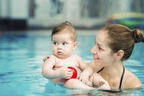 Baby and mother in water swimming pool. — Stock Photo