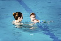 Baby boy with mother in swimming pool water. — Stock Photo