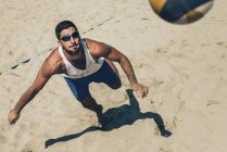 Vista de ángulo alto del voleibol de playa corriendo sobre arena con pelota . - foto de stock
