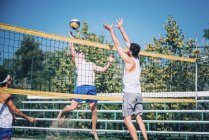 Beach volleyball players in action with ball at net. — Stock Photo