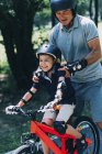 Avô e neto gostam de andar de bicicleta no parque de verão
. — Fotografia de Stock